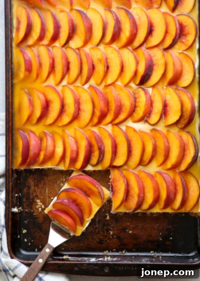 Close-up of the layers in a peach delight square: graham cracker, cream cheese, and peach topping.