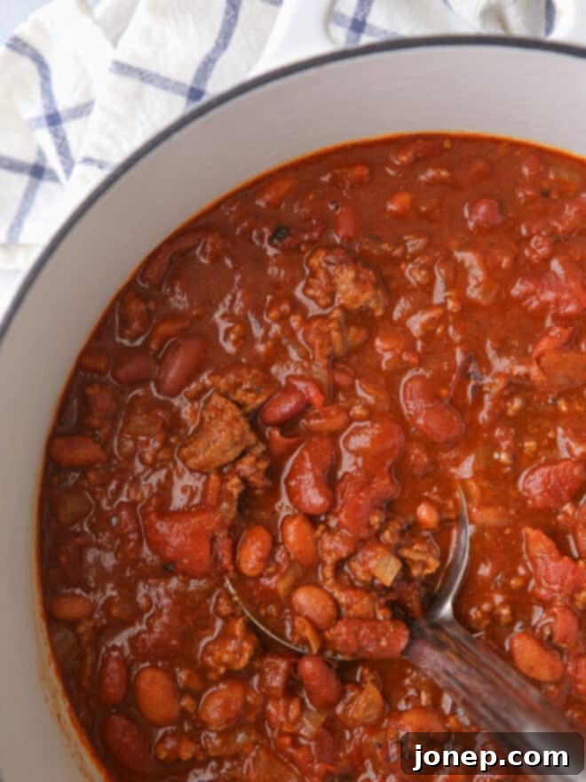 Effortless Weeknight Chili 5 Close-up of hearty chili simmering in a large pot with a ladle, showing rich texture