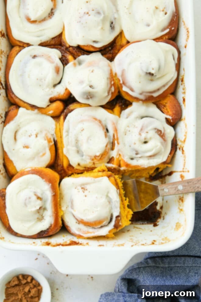 Cozy Fall Pumpkin Cinnamon Rolls 2 scooping pumpkin cinnamon