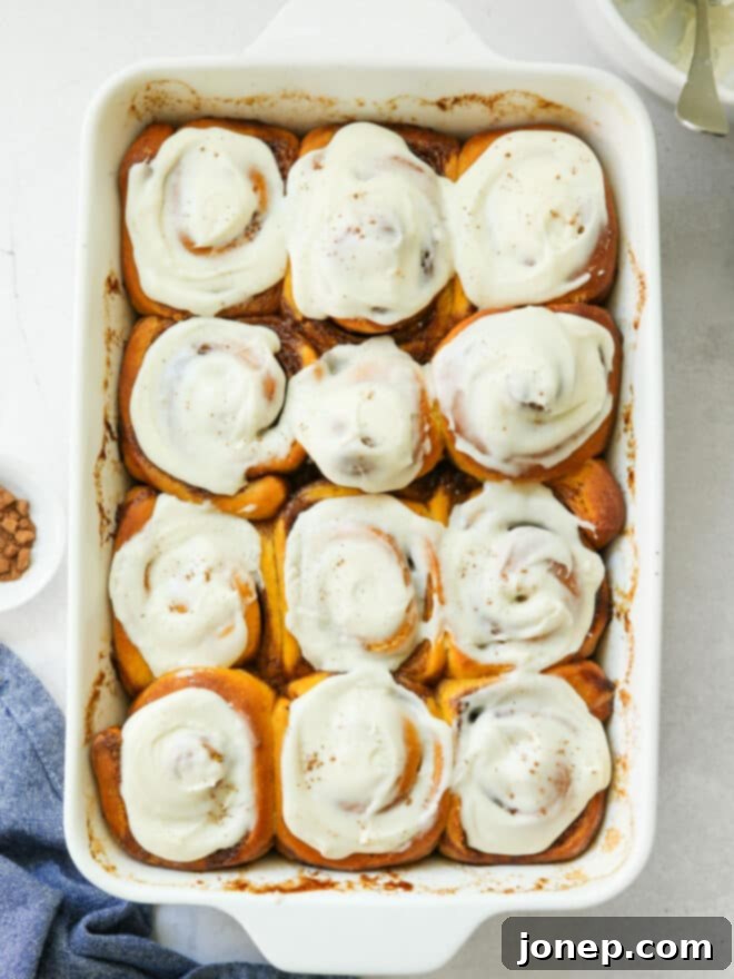 Cozy Fall Pumpkin Cinnamon Rolls 5 frosted pumpkin cinnamon rolls in baking pan