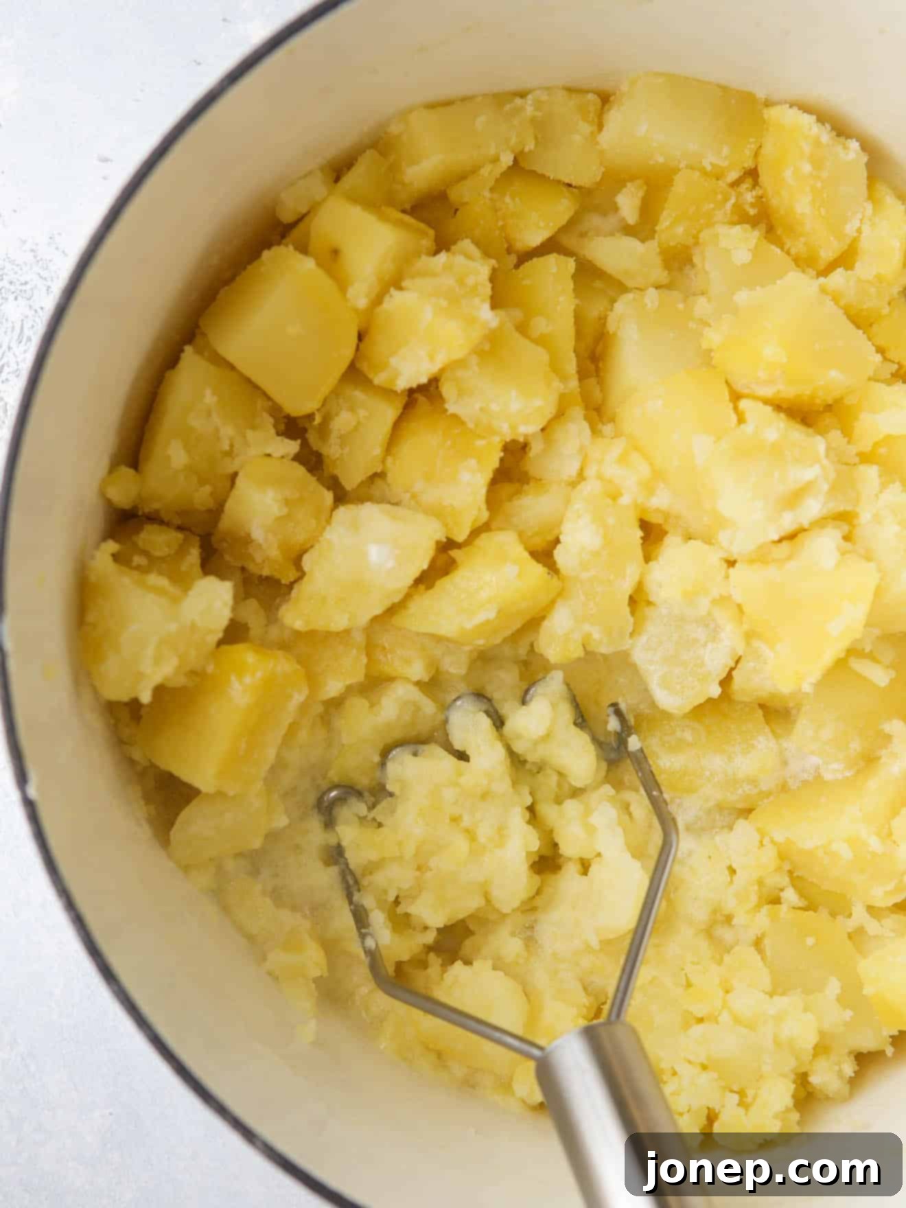 mashing potatoes in pot