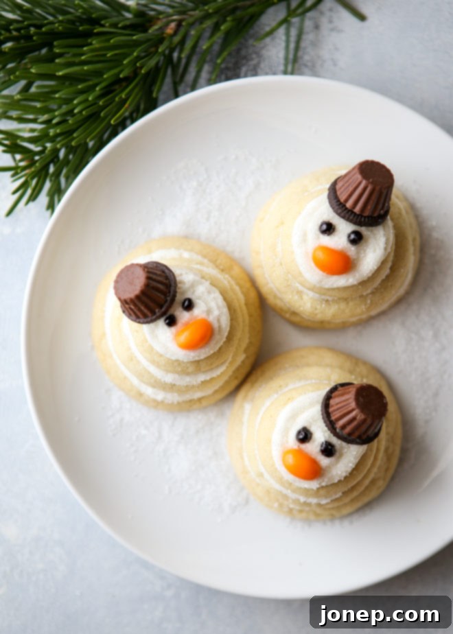 Adorable stacked snowman sugar cookies with frosting, jelly bean noses, and mini Oreo hats