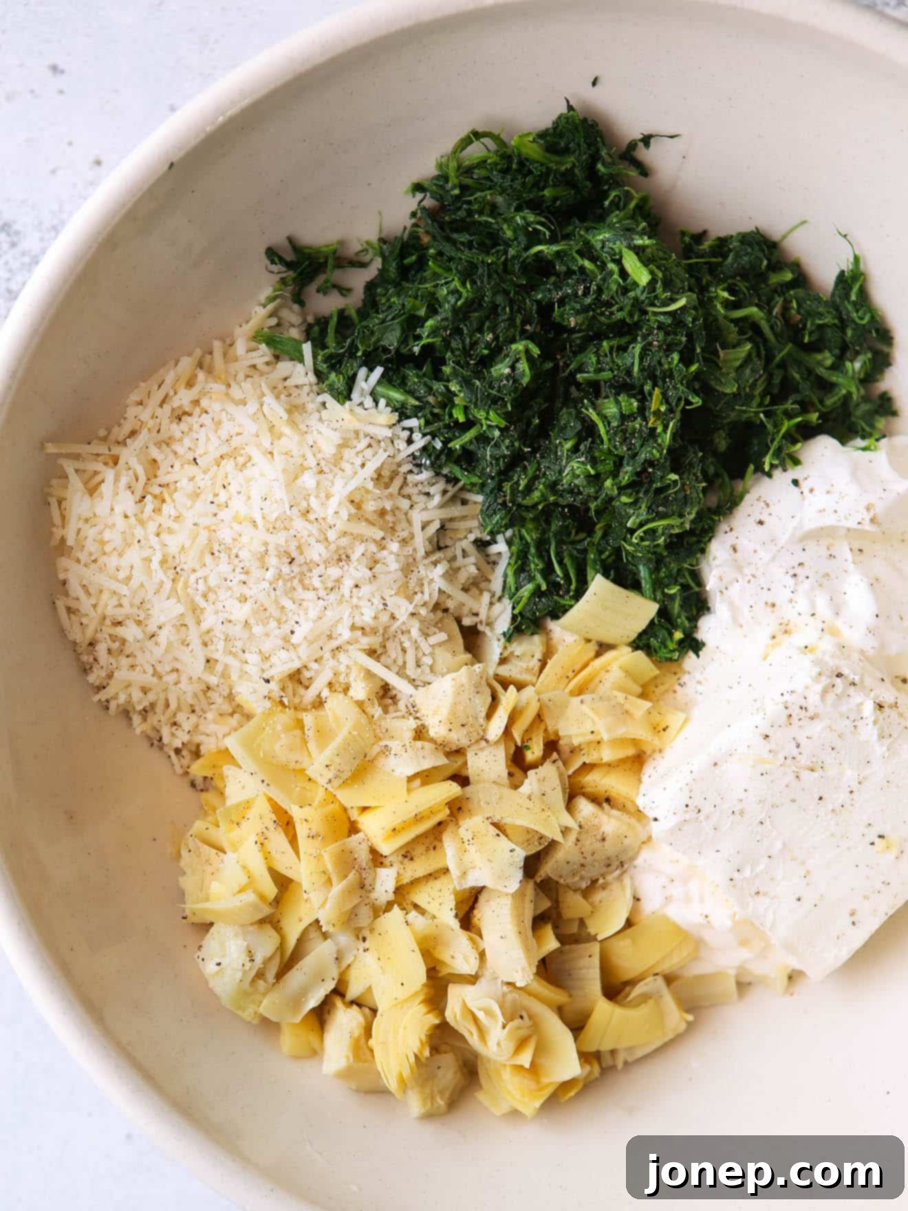 mixing spinach artichoke filling in a bowl