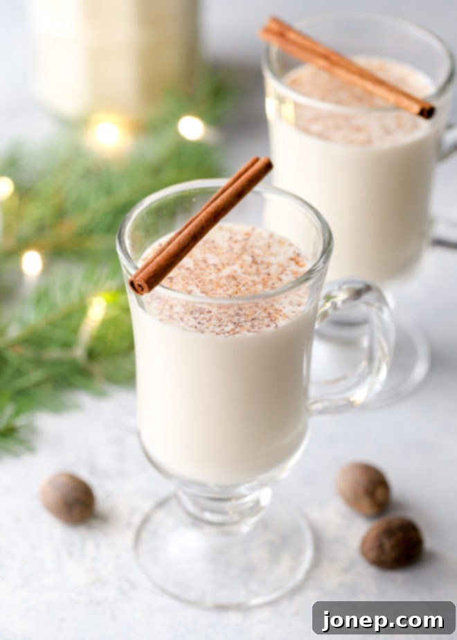 Homemade eggnog garnished with fresh nutmeg and whipped cream, ready to serve.