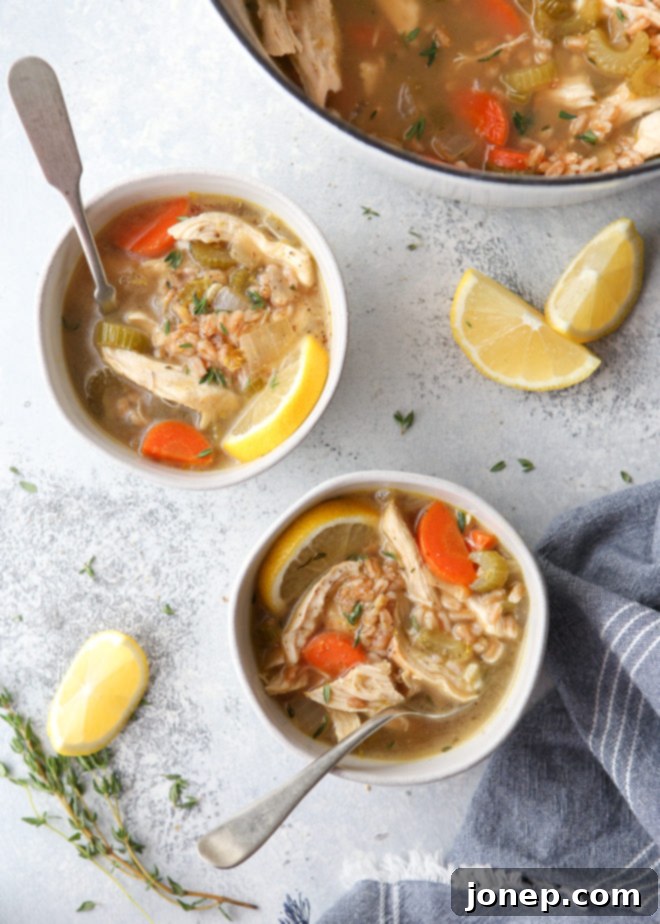 This lemon, chicken, and farro soup is hearty and wholesome! A close-up shot of the soup in a bowl with a spoon.