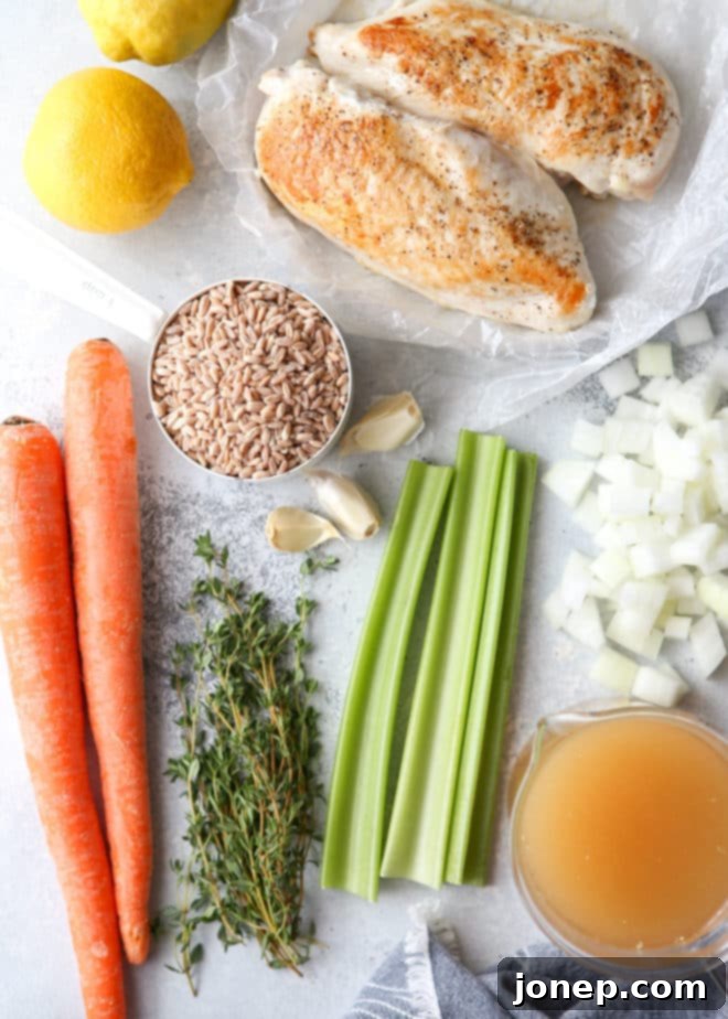 Hearty ingredients needed for lemon, chicken, and farro soup displayed on a wooden board