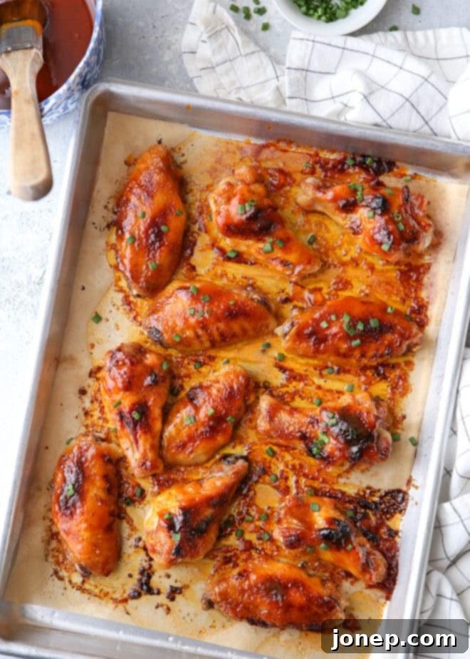 Crispy chicken wings tossed in a sweet and spicy maple glaze, garnished with fresh chives.