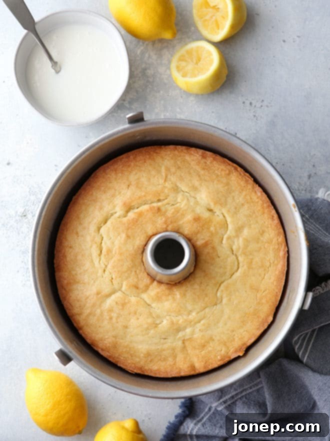 A close-up view of the perfectly moist interior crumb of a Lemon Cream Cheese Pound Cake, showing the delicate structure and the glistening sheen of the lemon glaze.