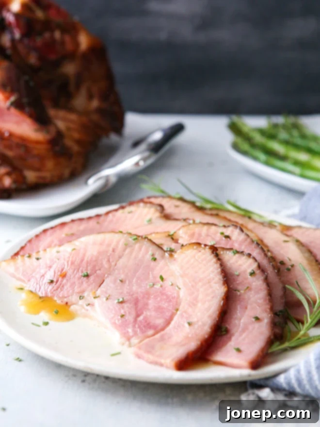 This honey-butter glazed ham recipe made with honey, butter, garlic, and rosemary is sweet and flavorful and only requires a few minutes of prep! Features a succulent spiral ham with a golden, sticky glaze.