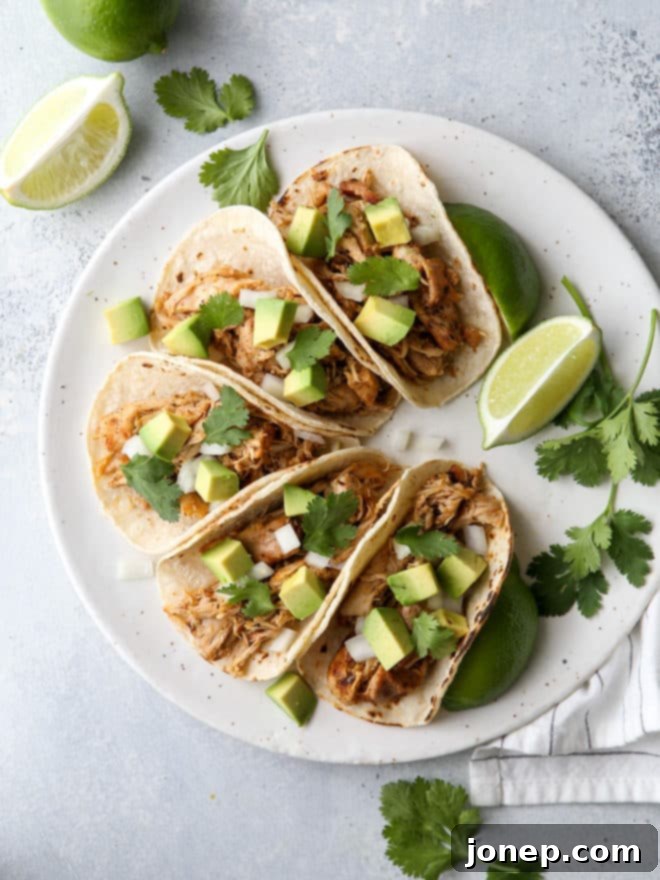 These easy Mexican street tacos filled with spiced shredded chicken, chopped onions, avocado, and cilantro are sure to become a favorite with everyone!