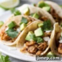 These easy Mexican street tacos filled with spiced shredded chicken, chopped onions, avocado, and cilantro are sure to become a favorite with everyone!