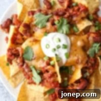 Ultimate Chili Cheese Nachos 7 Topped with quick and easy homemade chili, plenty of cheddar cheese and sour cream, these nachos are sure to be a big hit!