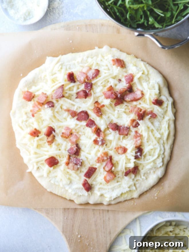 This simple but irresistible three-cheese white pizza is topped with crispy bacon and fresh arugula for maximum flavor.