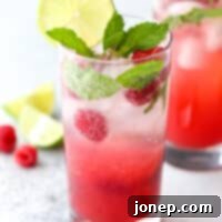 This refreshing mojito cocktail made with rum, mint, lime, and fresh raspberries is perfect for summer sipping!