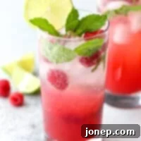 This refreshing mojito cocktail made with rum, mint, lime, and fresh raspberries is perfect for summer sipping!