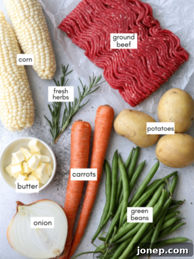 A close-up of prepared ingredients for beef and veggie foil dinners, including chopped potatoes, carrots, corn, green beans, and ground beef, ready for assembly.