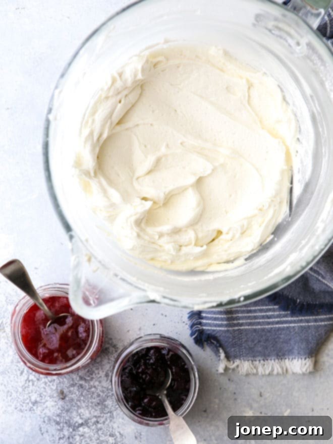 Vanilla buttercream frosting about to be swirled with berry preserves