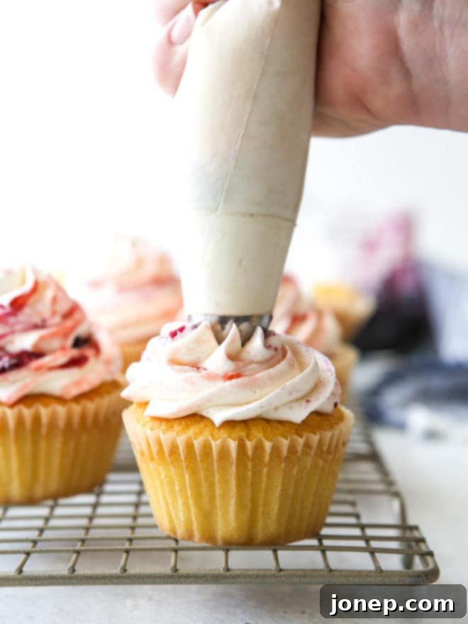 Delicate vanilla cupcakes topped with buttercream frosting swirled with berry preserves are lovely and delicious!