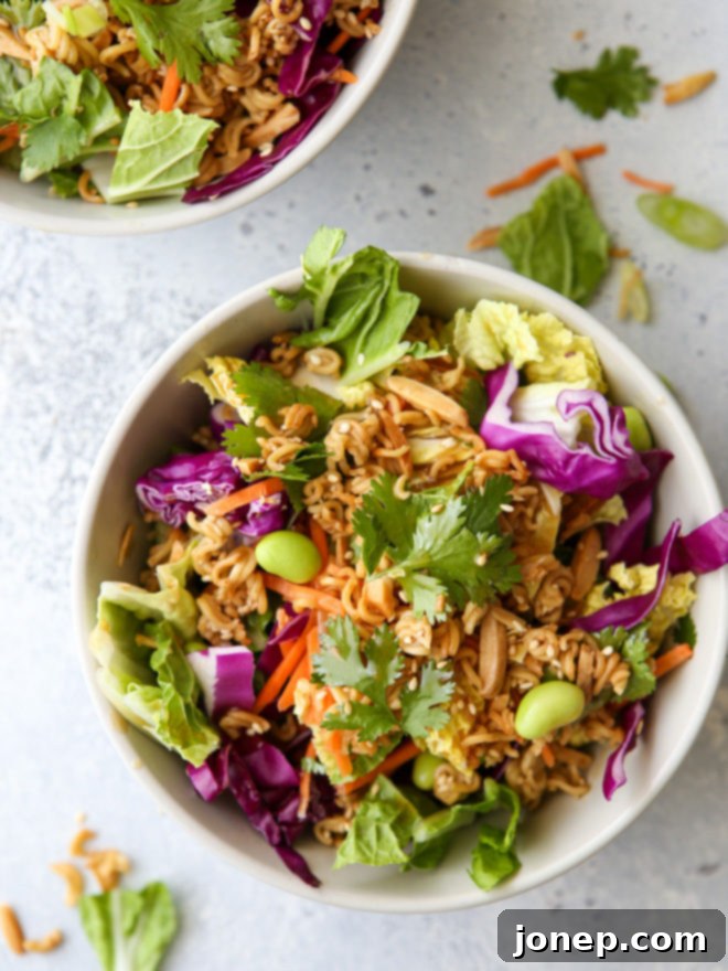 This Asian ramen cabbage salad is filled with napa and purple cabbage, shredded carrots, scallions, shelled edamame, crunchy ramen noodles, slivered almonds and a peanut sesame dressing.