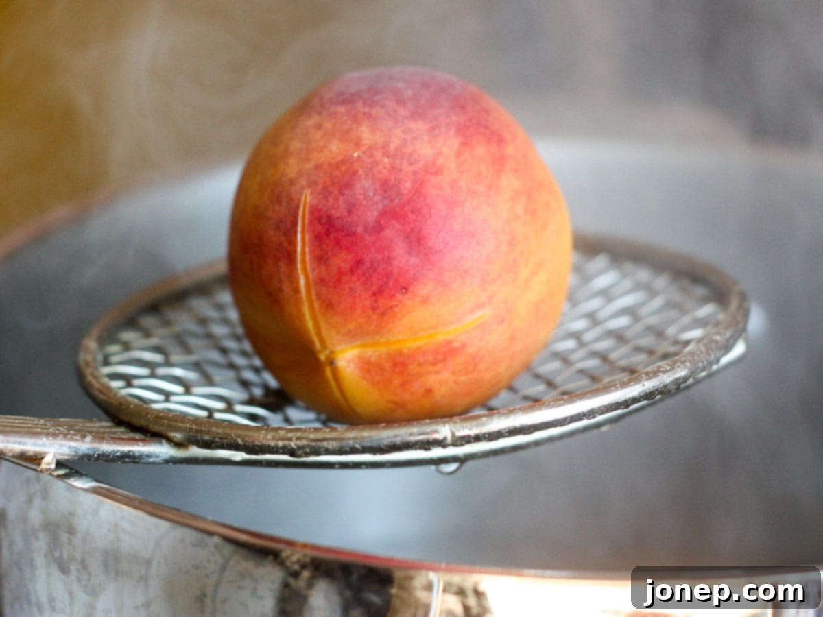 Blanched peach removed from boiling water, showing loosened skin