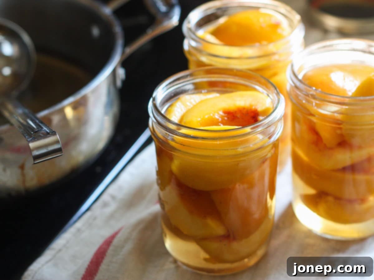 Filling canning jars with peeled peach slices and hot syrup, maintaining headspace