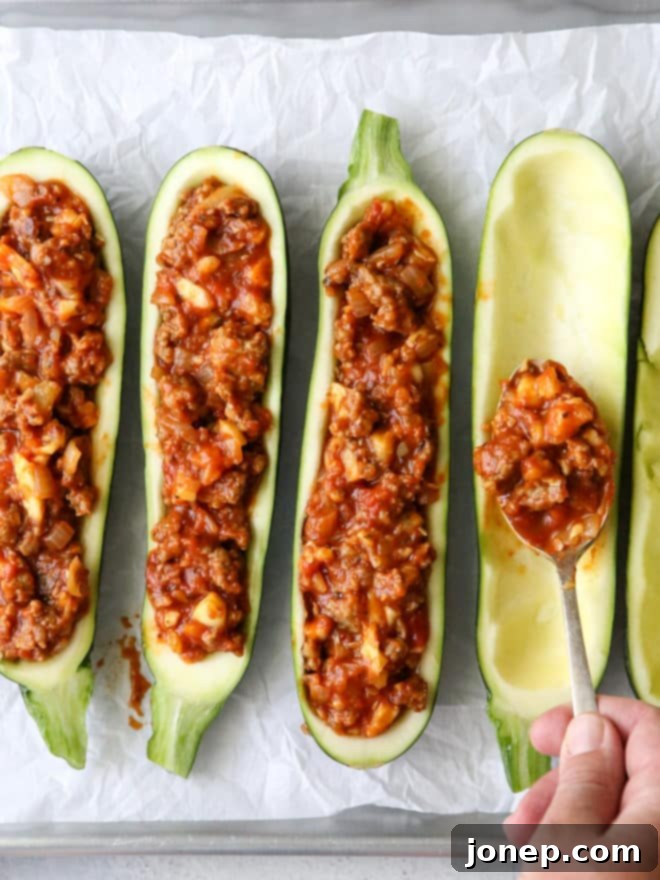Making sausage stuffed zucchini boats