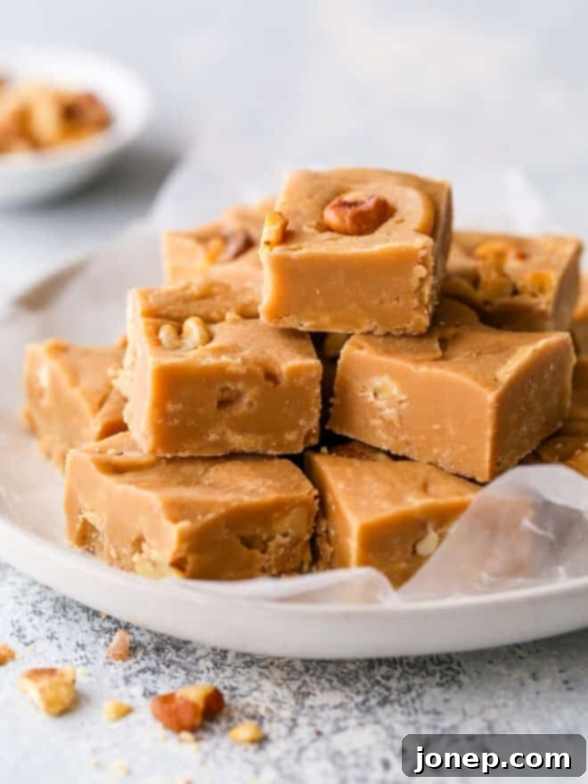 Golden Penuche Brown Sugar Fudge 2 sliced brown sugar fudge on a plate, showcasing its rich texture and walnut pieces