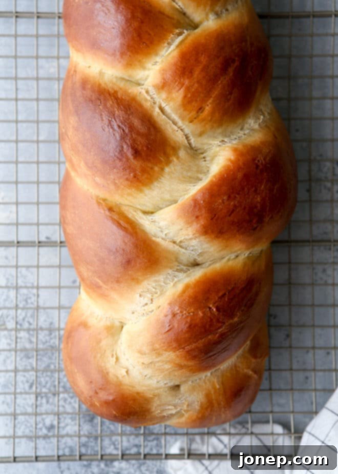 A slice of light, tender, and super flavorful braided egg bread showing its soft crumb