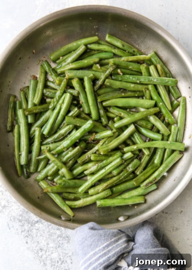 A close-up of simple and flavorful buttery garlic green beans, showcasing their vibrant green color, tender texture, and a hint of lemon, making them the perfect veggie side dish.