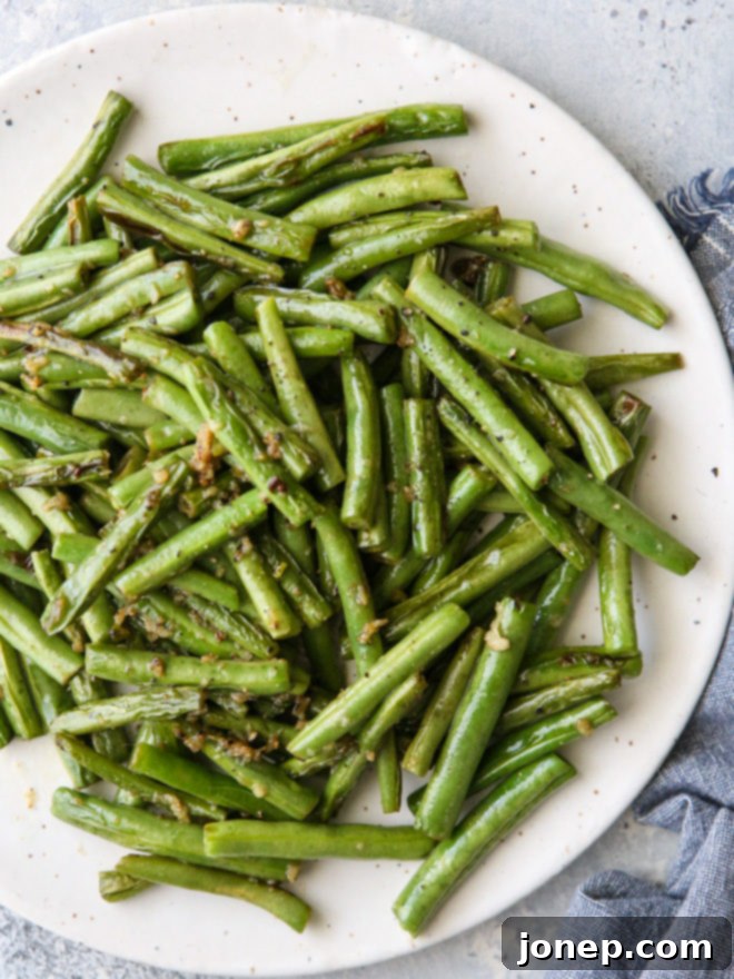 A serving of simple and flavorful buttery garlic green beans, perfectly cooked and ready to be enjoyed as the ultimate veggie side dish.