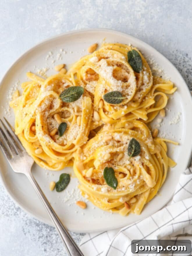 plated pumpkin alfredo pasta with garnishes on a plate with fork