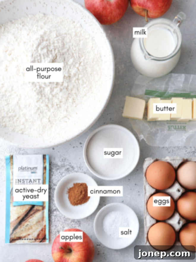 Golden Apple Delights 4 Ingredients measured out for homemade apple fritters, including flour, active-dry yeast, butter, eggs, milk, fresh apples, cinnamon, sugar, and pure maple syrup, all ready for baking