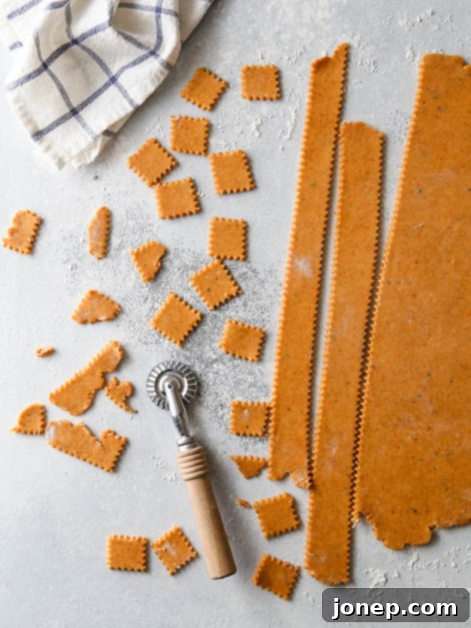 Sweet potato and cheddar crackers cut into squares on a baking sheet before baking