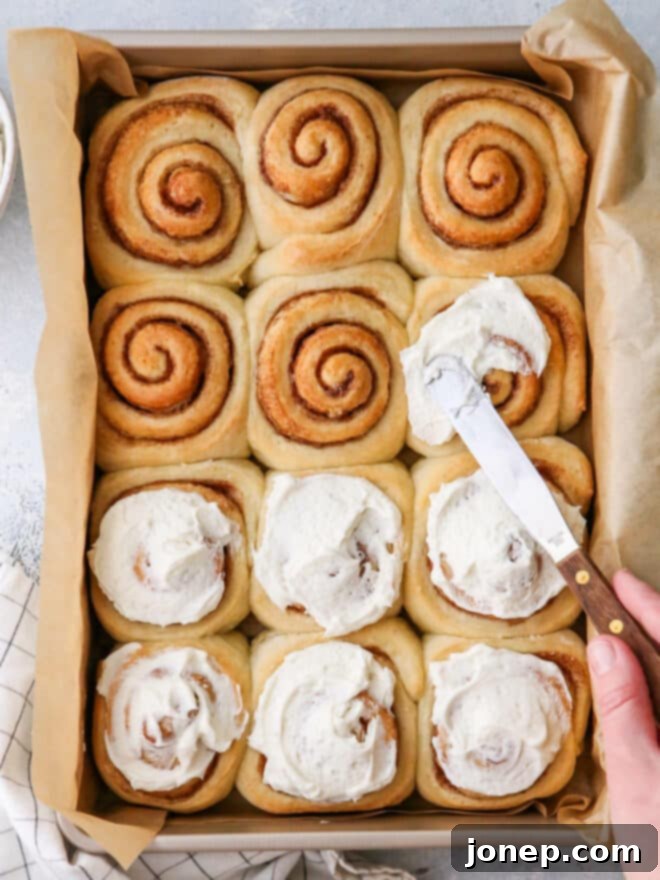frosting the baked cinnamon rolls