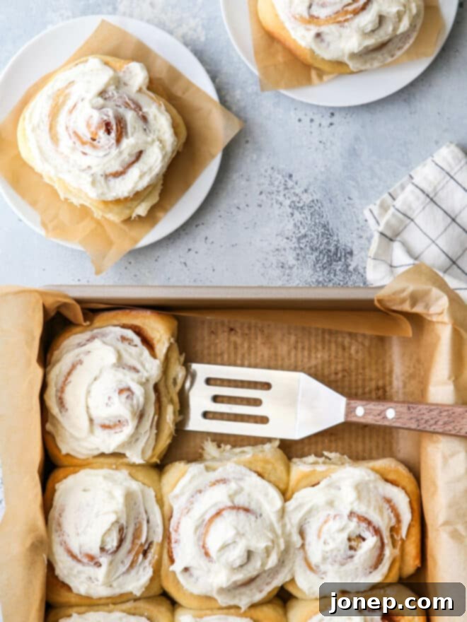 dishing up cinnamon rolls onto a plate