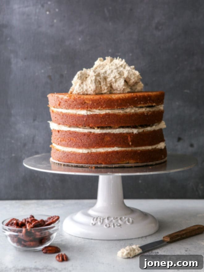 Putting together this brown sugar cinnamon layer cake with frosting and pecans