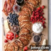 Craft Your Custom Pancake Board 6 A mouth-watering image of the "build your own" pancake board, richly topped and ready to serve, highlighting its appeal for any meal.