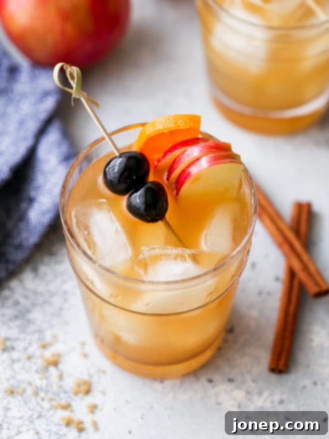 closeup of apple cider old fashioned in a glass with a large ice cube