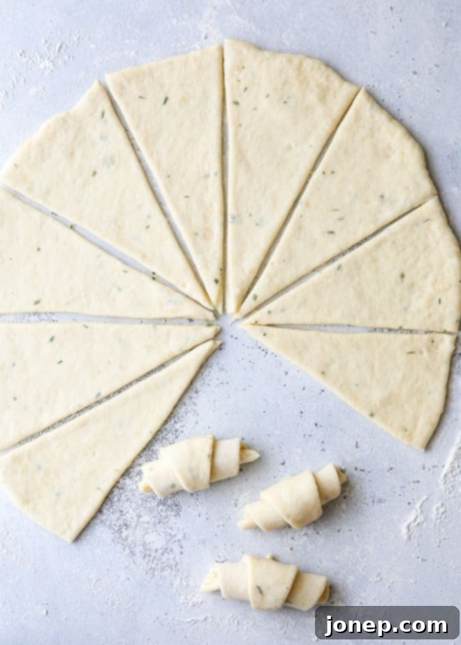 Rolling and slicing the no-knead dough into triangles to form garlic and herb crescent rolls