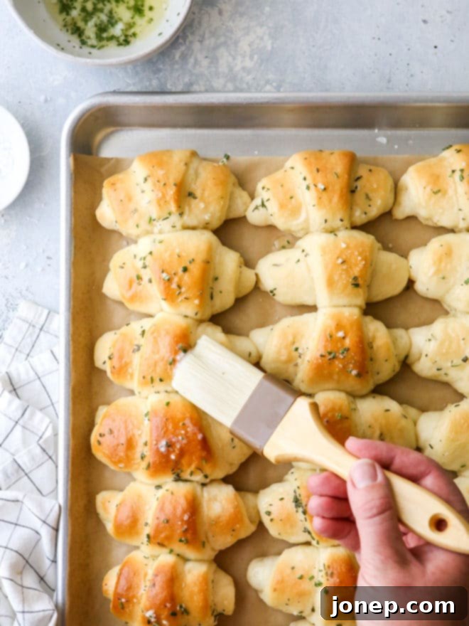 A close-up shot of warm, buttery garlic and herb crescent rolls, beautifully golden and ready to be enjoyed