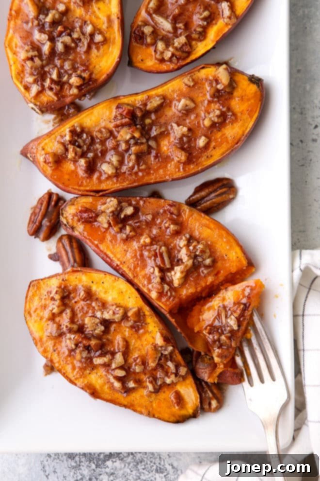 Platter of roasted sweet potatoes with maple pecan sauce, ready to serve.