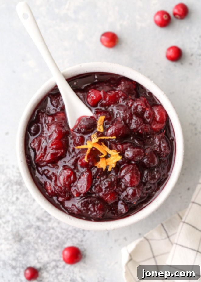 Zesty Spiced Cranberry Relish 5 A beautifully set holiday table featuring a bowl of citrus spice cranberry sauce, surrounded by other festive dishes and decorations.