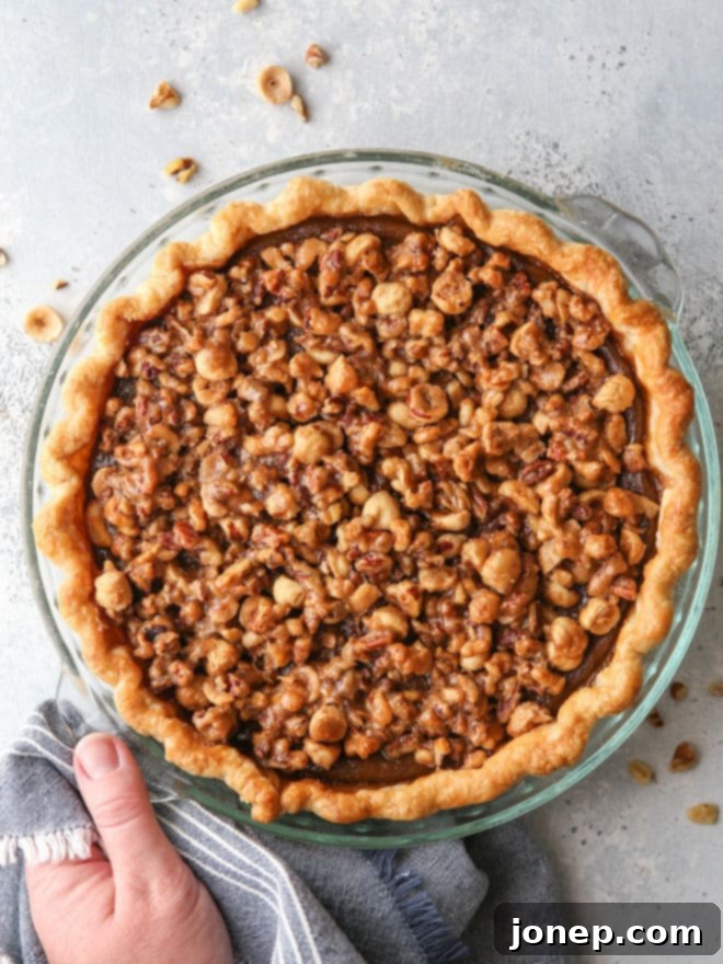 A stunning slice of pumpkin pie with nut praline, showcasing the creamy filling and crunchy topping.