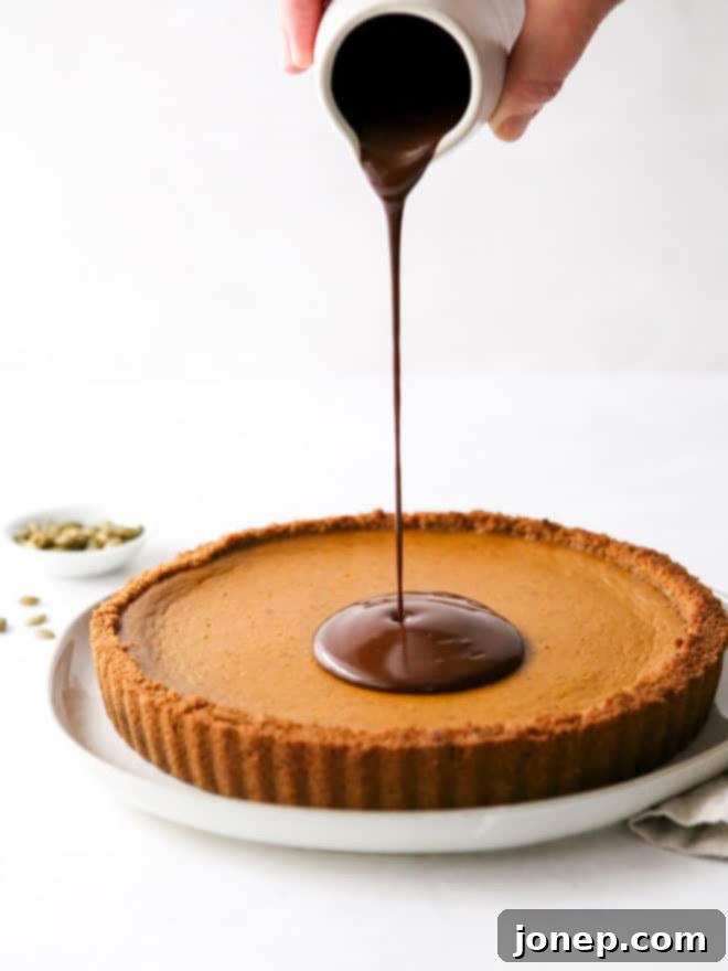 pouring chocolate ganache on pumpkin tart