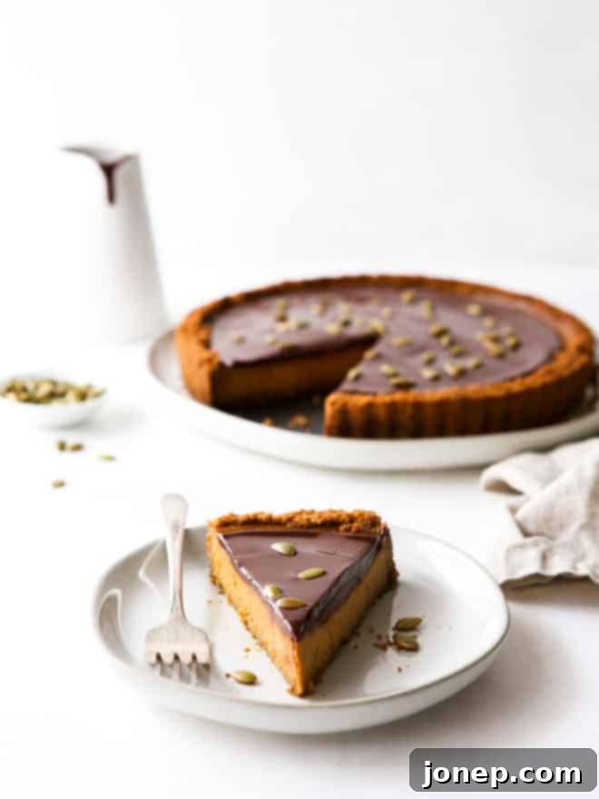 slice of chocolate pumpkin tart on a plate with full tart in background