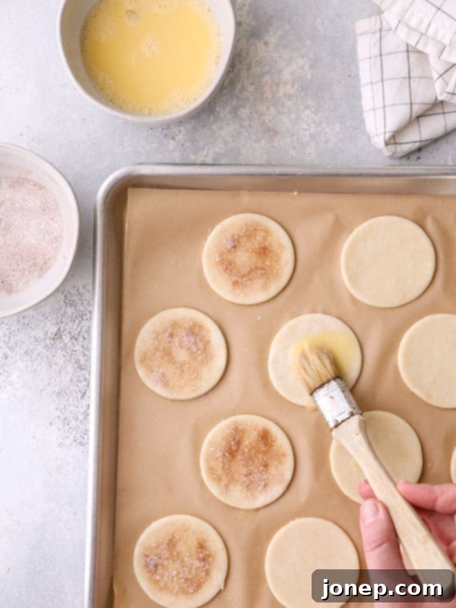Upcycled Pie Dough Bites 4 Brushing pie crust cutouts with egg wash before sprinkling with cinnamon sugar