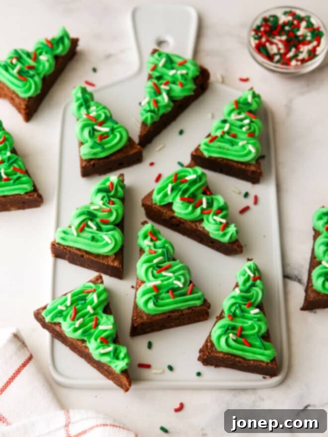 Fudgy Frosted Brownie Shapes 2 Frosted brownie cut-outs shaped and decorated like mini Christmas trees with green frosting and colorful sprinkles