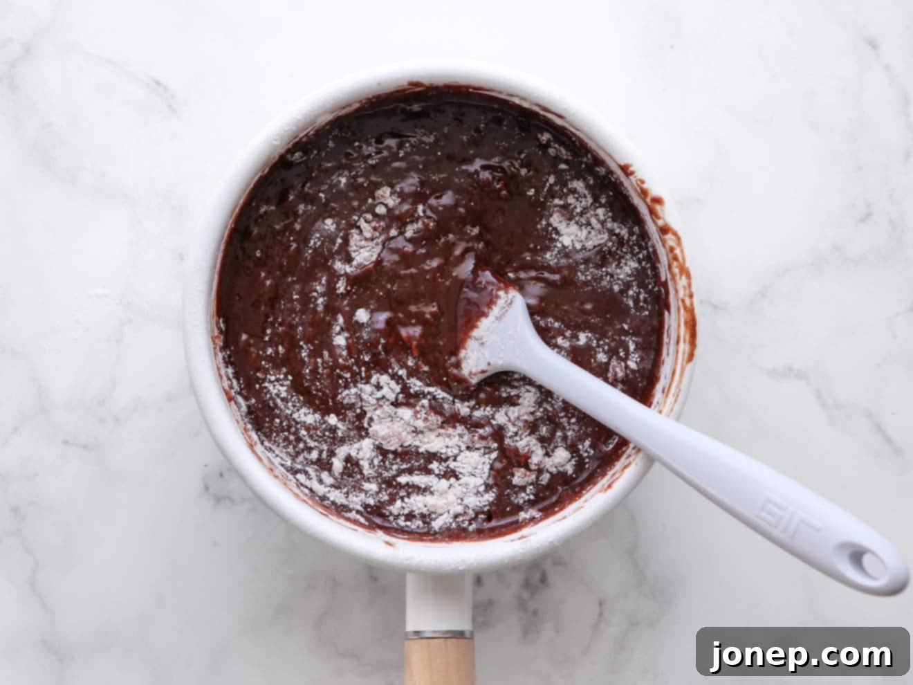 Step-by-step image showing brownie batter being mixed in a bowl