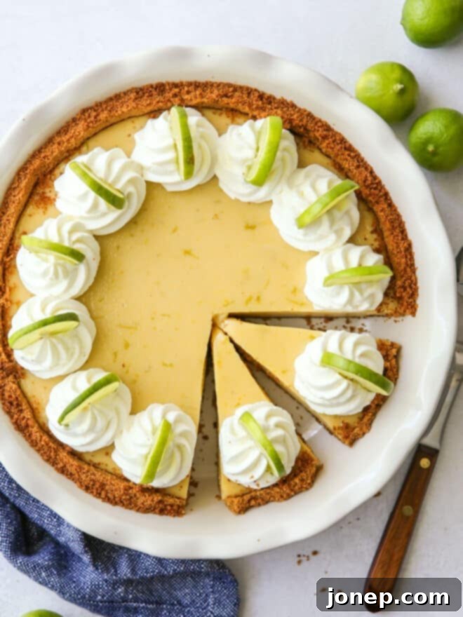 The Zesty Heart of the Florida Keys 9 Top-down view of a whole Key Lime Pie, expertly sliced with several pieces removed, revealing the creamy filling and a swirl of whipped cream on top.