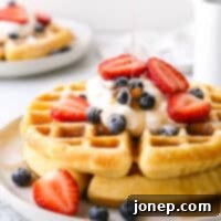 Crispy Fluffy Buttermilk Waffles 8 A stack of golden buttermilk waffles with a light syrup drizzle, ready for serving.